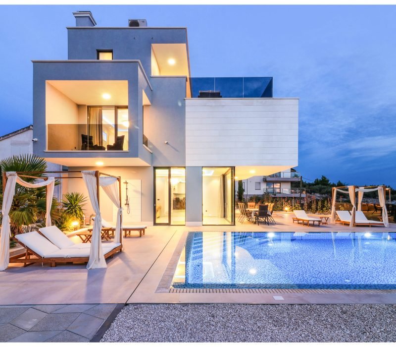 Dusk settles, lights come on, and the water is still warm enough for an evening swim. Sliding doors open straight from the living room to the terrace table